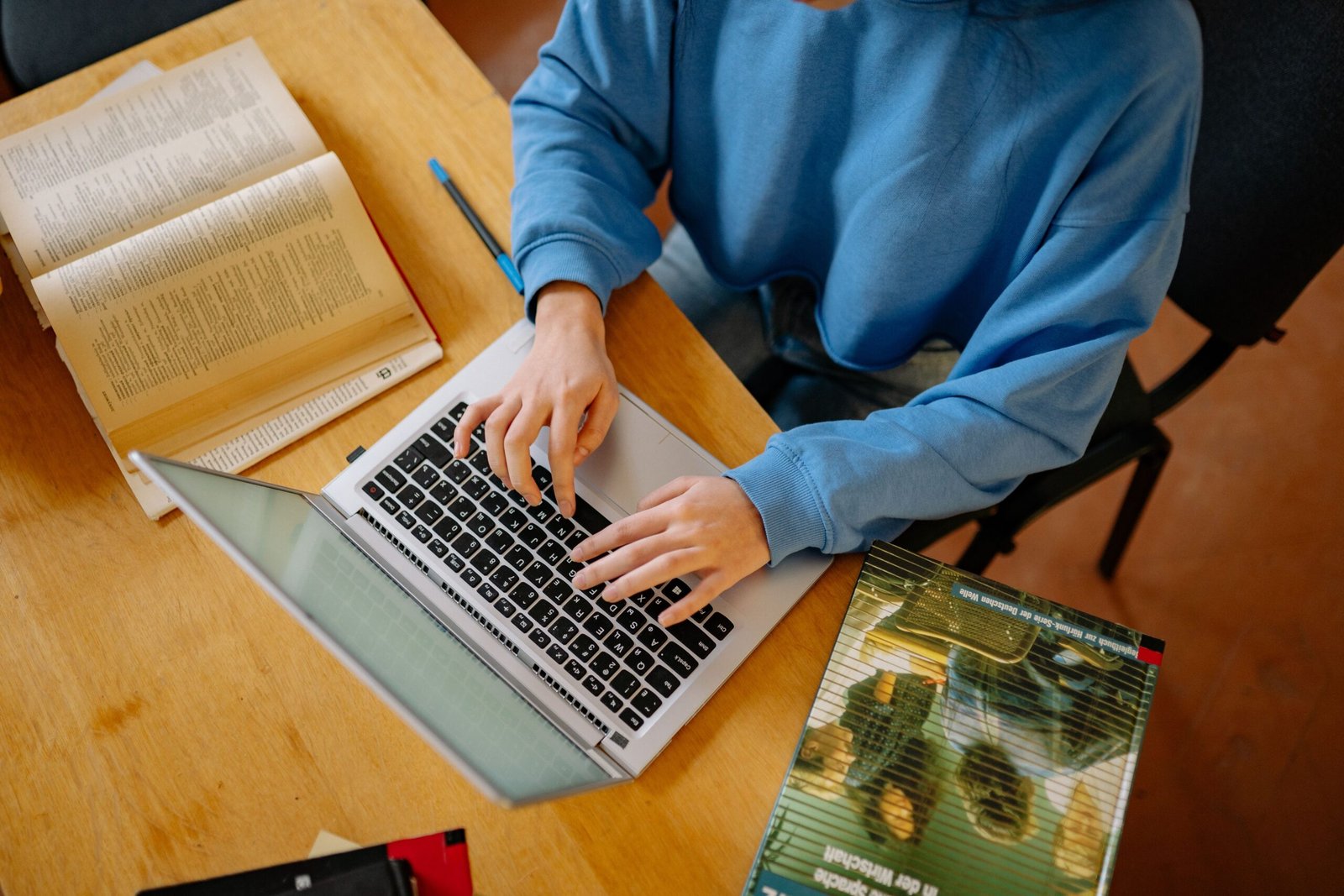 https://www.pexels.com/photo/person-in-blue-sweater-using-a-laptop-8199246/